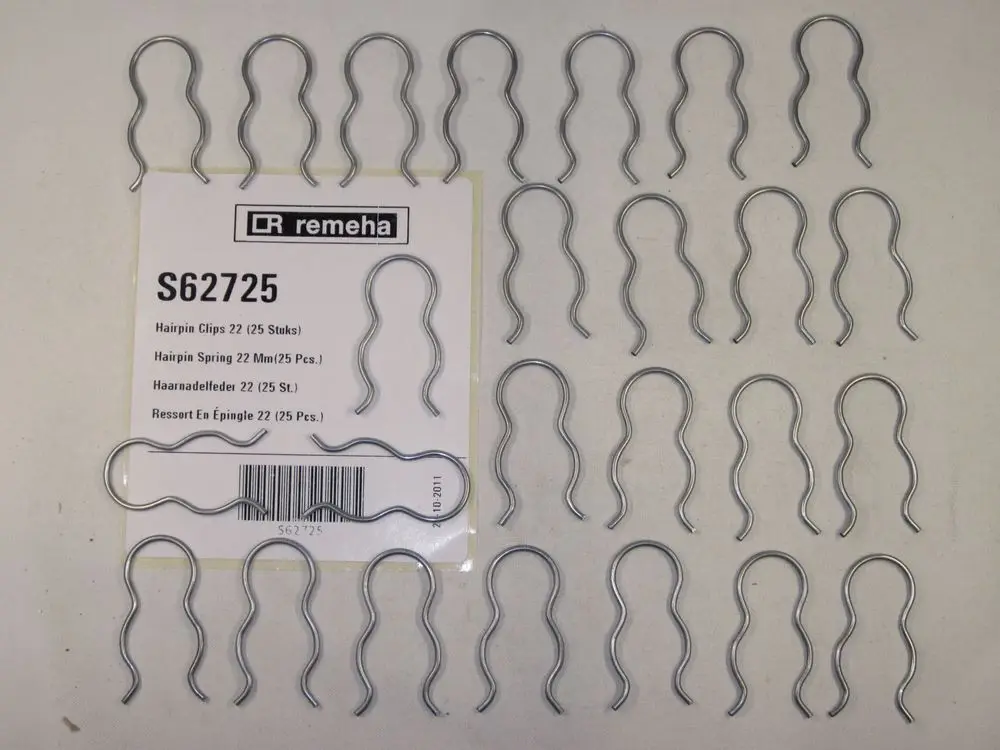 Haarnadelfedern in metallischer Ausführung, angeordnet auf einer Verpackung mit dem Logo der Marke Remeha. Enthalten sind mehrere Clips in einer geordneten Anordnung.